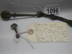 A Victorian device for a lady to lift her skirt and another for clipping an kerchief to a ladies