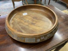 A large teak fruit bowl inlaid with sixpences in numerical order from 1909-1964 along with Latin