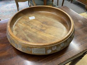 A large teak fruit bowl inlaid with sixpences in numerical order from 1909-1964 along with Latin