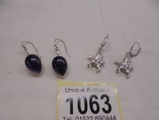 A pair of silver pendant earrings and a pair of silver Pegasus earrings.