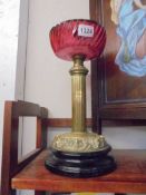A brass oil lamp base with cranberry glass font (font a/f, crack to underside).