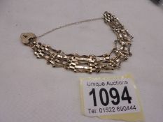 A 9ct gold bracelet with padlock, some damage to links, 9.87 grams.