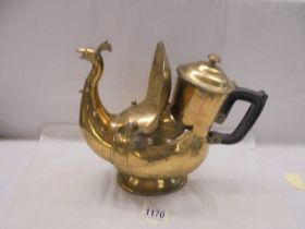 An early 20th century Eastern brass teapot in the form of a peacock.