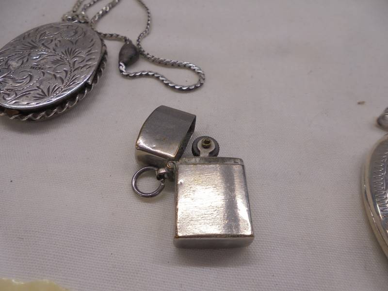 A silver locket, two white metal lockets and a miniature cigarette lighter. - Image 5 of 5