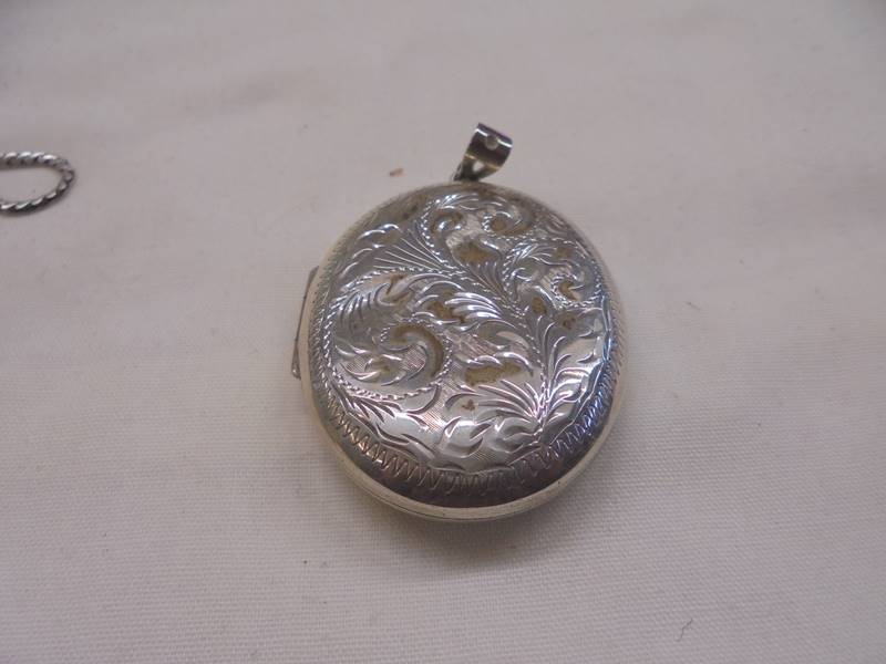 A silver locket, two white metal lockets and a miniature cigarette lighter. - Image 2 of 5