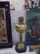 A brass oil lamp with reeded column on a ceramic base, COLLECT ONLY.