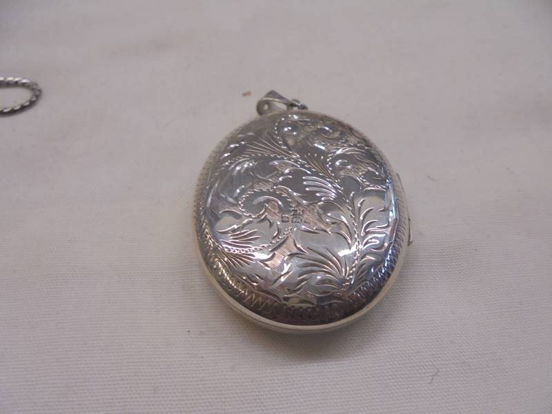 A silver locket, two white metal lockets and a miniature cigarette lighter. - Image 3 of 5