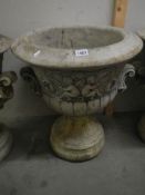 A moulded cherub garden urn in two pieces for ease of transportation, approximately 70cm tall,