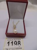 9ct yellow gold necklace with a suspended pear drop cultured pearl and R/C diamond-set bale, boxed.