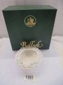 A boxed Belleek basket weave dish with floral decorated rim.