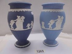 Two Wedgwood Jasper ware vases, one in dark blue and the other in pale blue.