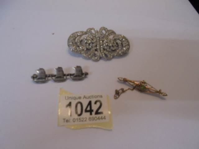 A vintage silver brooch designed as masted sailing ships together with a 9ct gold peridot brooch