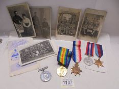 Three WW1 medals, Two WW2 medals and a quantity of military postcards.