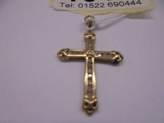 A 9ct yellow gold and diamond cross, 1.6 grams.
