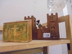 A wooden money box in the shape of a castle and one other.