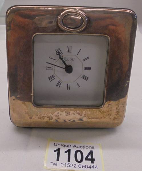 A silver fronted battery clock.