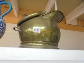 A brass coal scuttle.