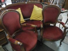 A mahogany three piece salon suite in red draylon upholstery. COLLECT ONLY.