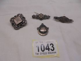 Three vintage silver brooches and a silver fob.