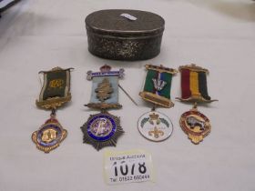 A metal box containing a silver Royal Order of Buffalo's medal and three others.