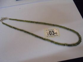 A gem necklace set with peridot beads (approximately 120 beads).