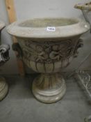 A moulded cherub garden urn in two pieces for ease of transportation, approximately 70cm tall,