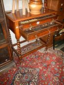 An Edwardian two drawer cutlery cabinet on wheels with a set of Sheffield Community plate cutlery,