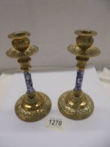 A pair of Victorian brass candlesticks with blue and white ceramic columns.
