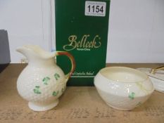 A boxed Belleek milk jug and an unboxed Belleek sugar bowl.