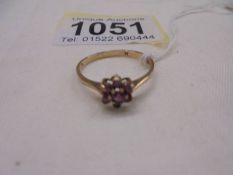 A ruby stone set ring in a cluster design, hall marked London 1965, size O half, 1.4 grams.