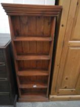 A narrow stained pine book case, 136 cm H x 52 cm W x 18 cm deep, COLLECT ONLY.