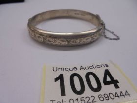 An engraved silver bangle. 15 grams.