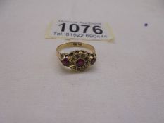 An 18ct gold rings set diamonds and possibly rubies, size M, 2.46 grams.