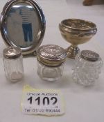 A small silver footed dish (dinted), three silver topped pots and a white metal photo frame.