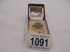 An 18ct gold and platinum three stone ring, size N half, 2 grams.