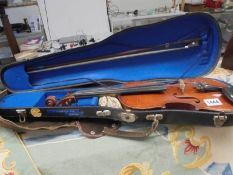 An old cased violin with bow.