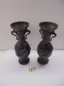 A pair of bronze vases with applied dragons, 17 cm tall.