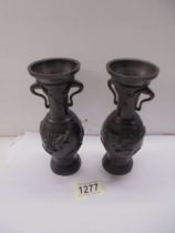 A pair of bronze vases with applied dragons, 17 cm tall.