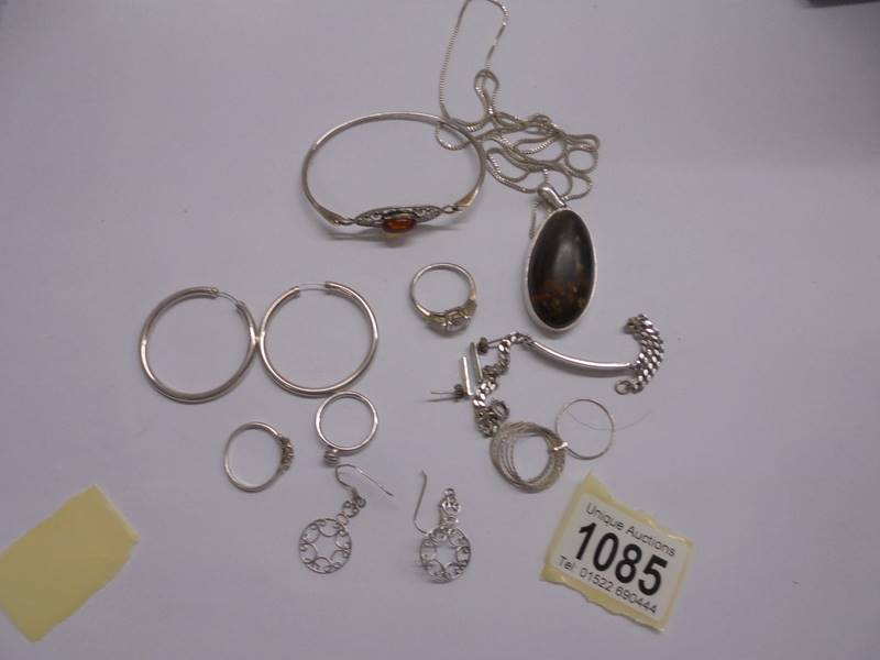 A mixed lot of silver jewellery including an amber pendant, amber set bracelet, rings, earrings etc