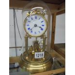 A good quality brass anniversary clock with enamel dial and under a plastic dome.
