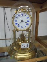 A good quality brass anniversary clock with enamel dial and under a plastic dome.