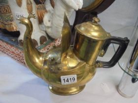 An unusual middle eastern brass teapot in the form of a peacock.