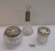 Two silver topped dressing table pots and a scent bottle.