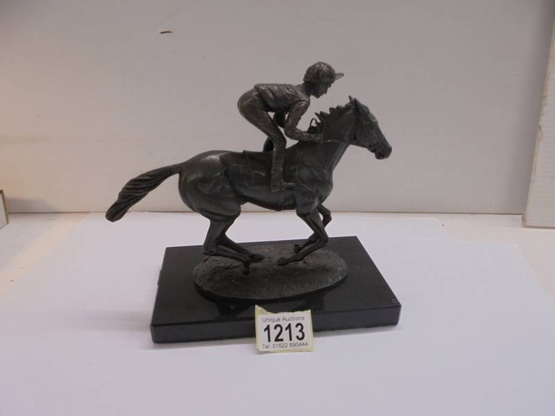 A signed bronze horse and jockey on a marble bases, signed David Cornell.