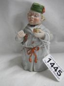 A 19th century candlesnuffer of a man in a dressing gown.