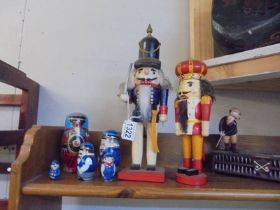 Two German nutcracker figures and a steam train painted set of Russian dolls.