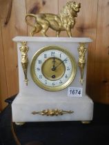 An alabaster mantel clock with lion on top. in working order.