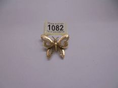 A Monet butterfly brooch in yellow metal.