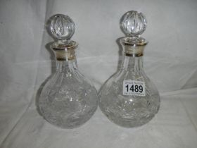 A pair of good cut glass decanters with hall marked silver collars.