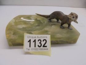 A cold painted bronze otter on an onyx tray.